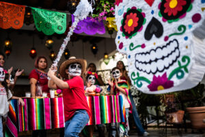 Boy hitting piñata during a day of the death celebration